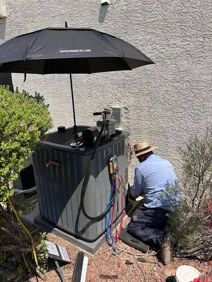 HVAC technician performing outdoor AC maintenance in Hamilton